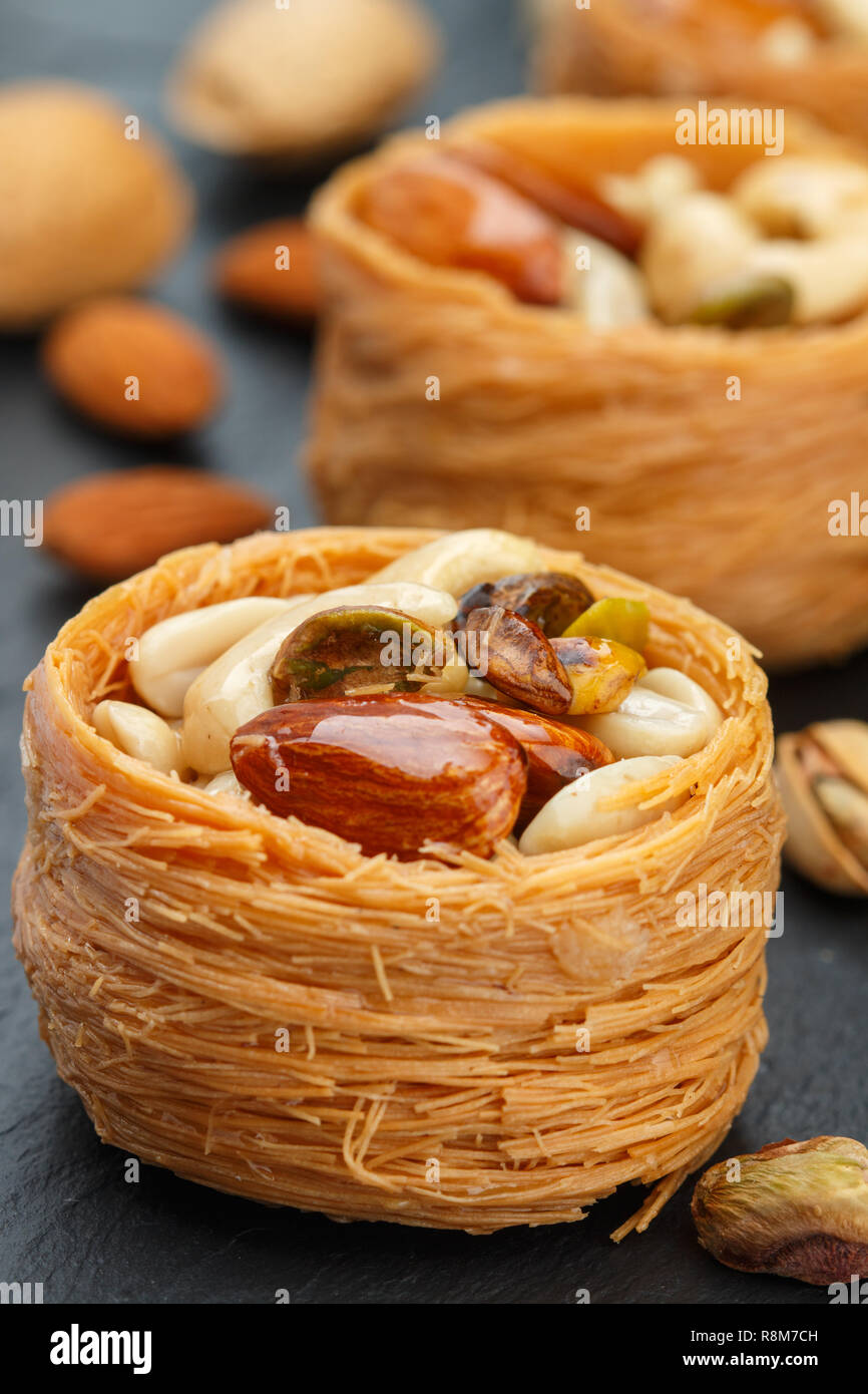 Traditional middle Eastern sweets "bird's nest" in honey syrup with nut filling - almonds, cashews, pistachios. Baklava close-up. Delicious dessert Stock Photo