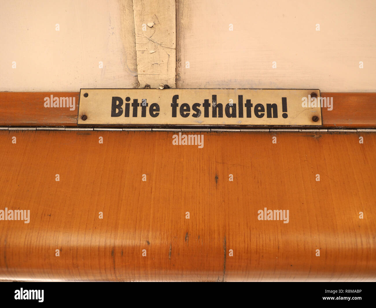 Bitte festhalten (meaning Please hold tight) sign on vintage German tram Stock Photo