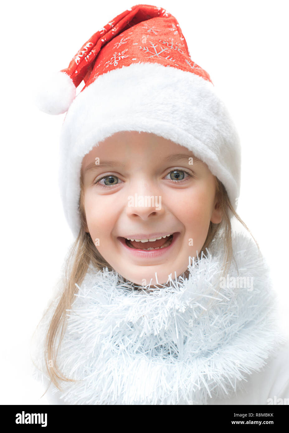 An adorable little girl, wearing a Santa Claus hat, with a happy laughing expression. Stock Photo