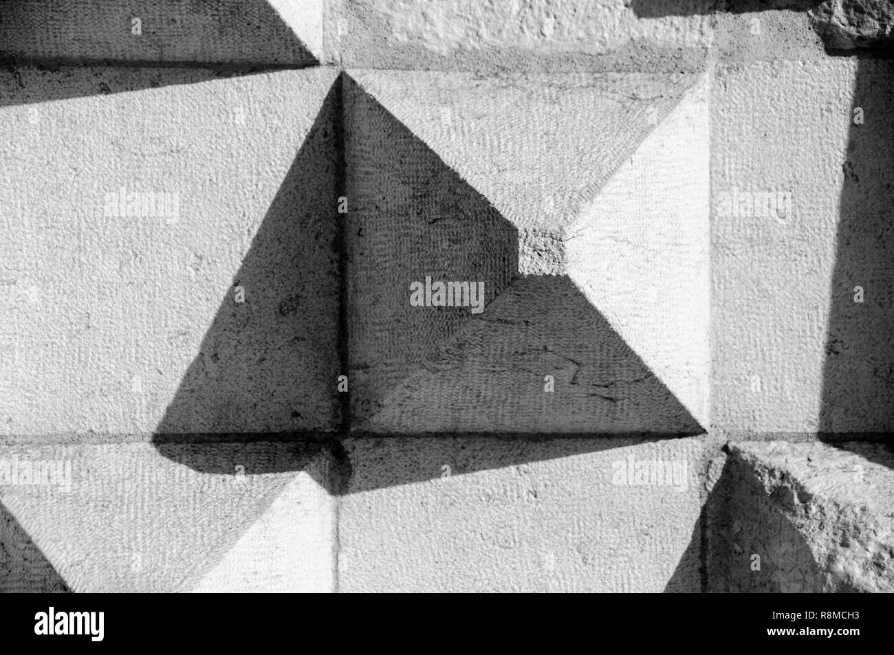 Close-up with a piramide-shape building wall and playing with the shadows Stock Photo