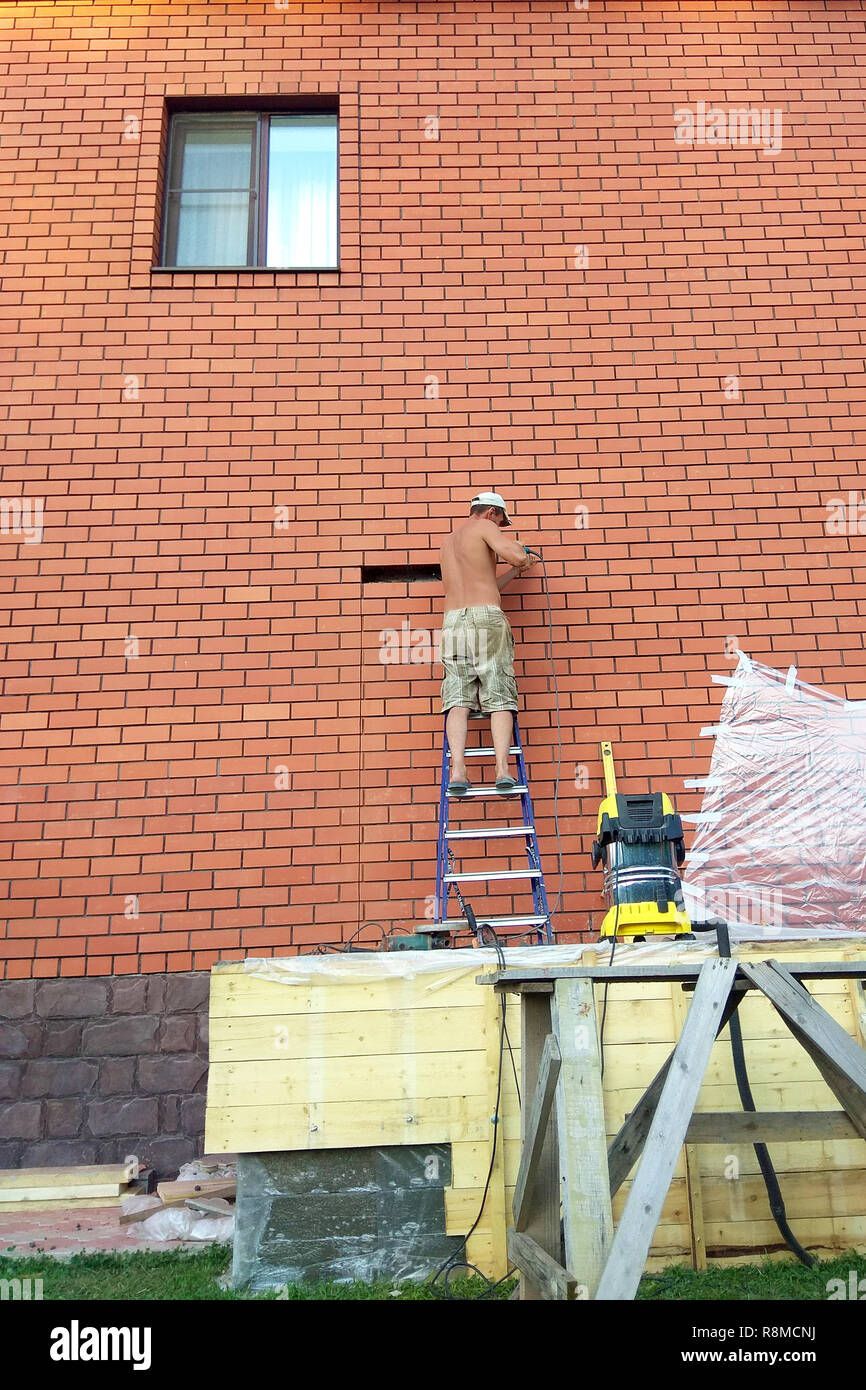 The builder performs work on the ladder 2018 Stock Photo