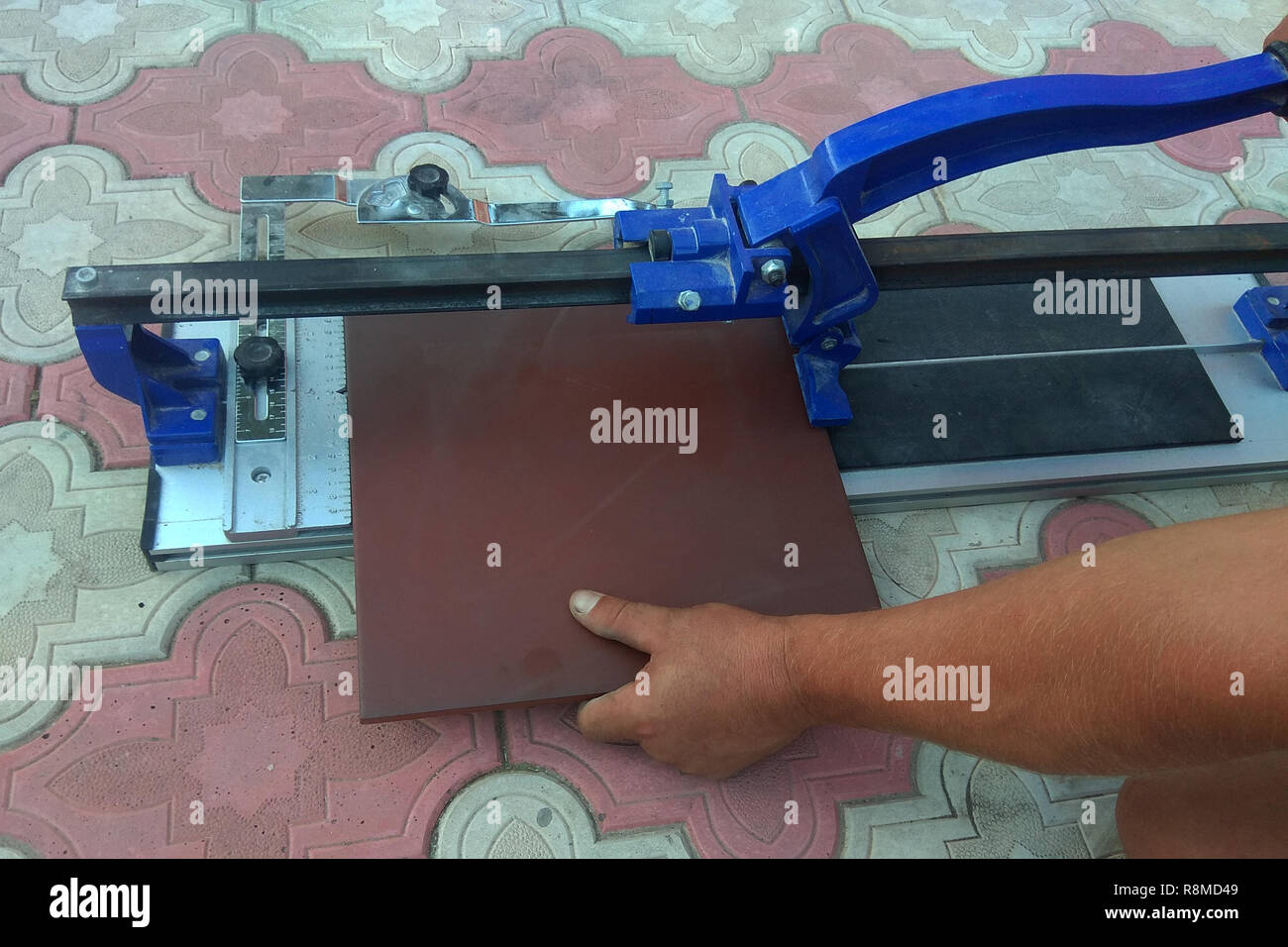 the worker cuts the ceramic tile on the manual tile 2018 Stock Photo