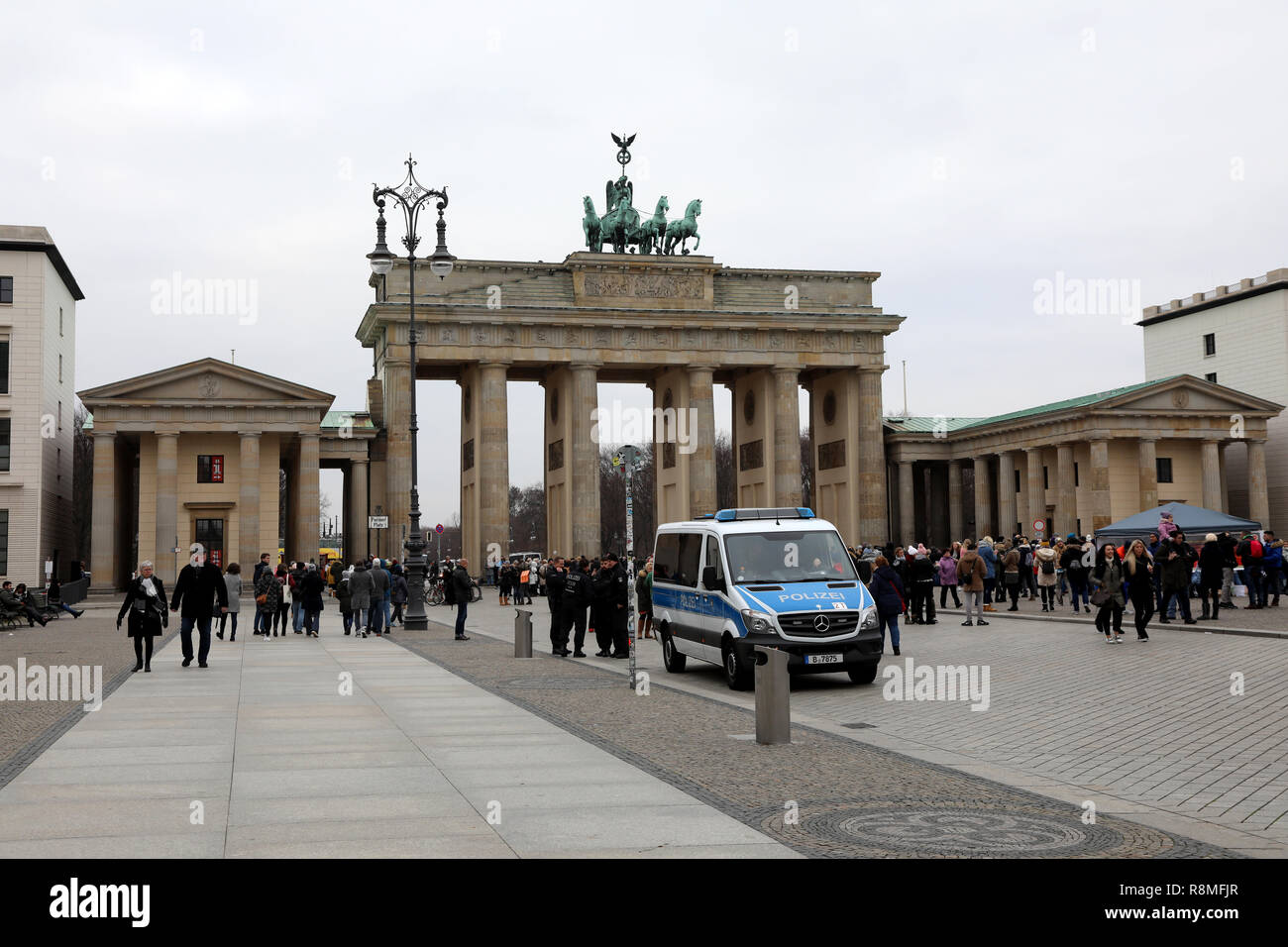 Berlin / Germany - December 15 2018: Tourists walk through and around the Brandenburg Gate on Unter den Linden in central Berlin Stock Photo