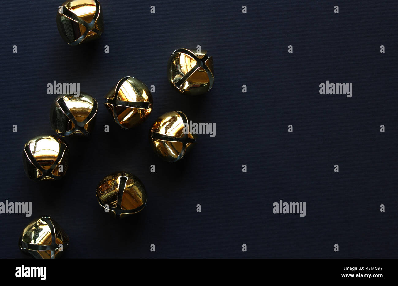 Gold jingle bells styled against black background. Copy space Stock