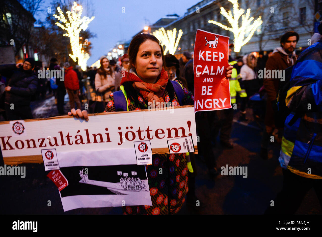 Budapest, Hungary. 16th Dec, 2018. A woman is seen holding a banner and placard during the protest against the new labour law approved by the right wing conservative government lead by Viktor Orban. The Hungarian government has passed a set of controversial laws on judicial and labour topics, The new labour law, known as 'slave law' allows employers to ask their workers to take on up to 400 hours' overtime per year. Credit: SOPA Images Limited/Alamy Live News Stock Photo