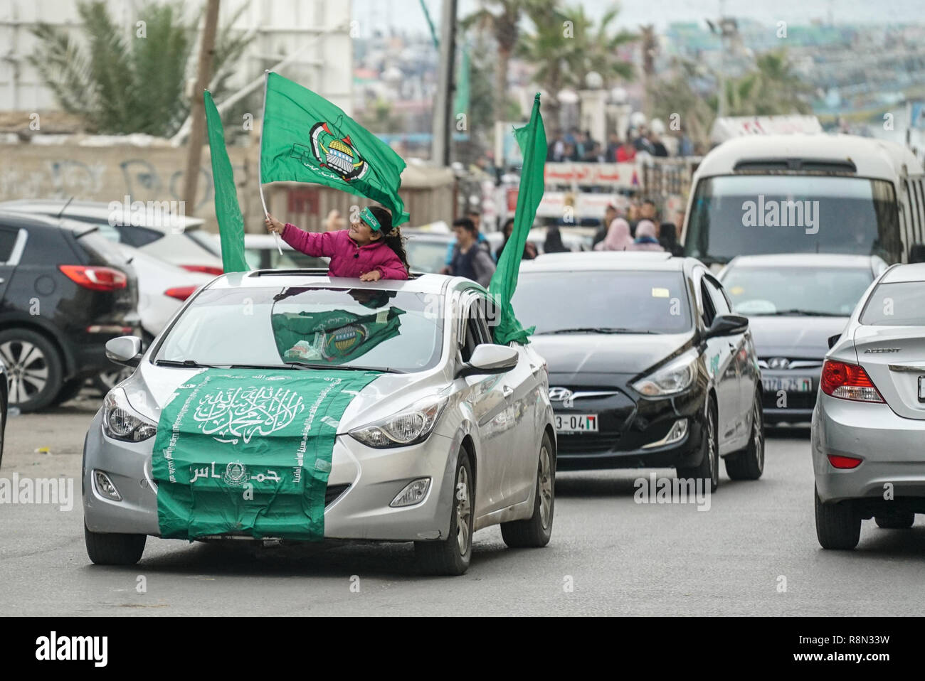 Gaza city, Palestine. 16th Dec, 2018. A Palestinian girl seen holding a flag through the roof of a vehicle during the rally. Palestinians take part in a rally marking the 31st anniversary of Hamas' founding. Credit: SOPA Images Limited/Alamy Live News Stock Photo