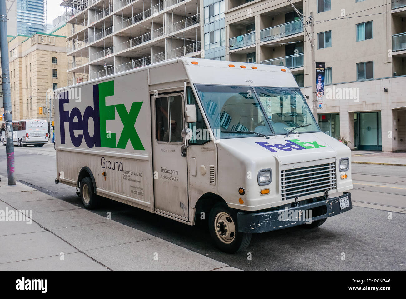 FedEx white delivery truck parked on the road Stock Photo