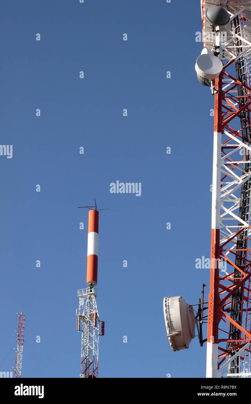 Several kind of communication antennas against deep blue sky Stock Photo