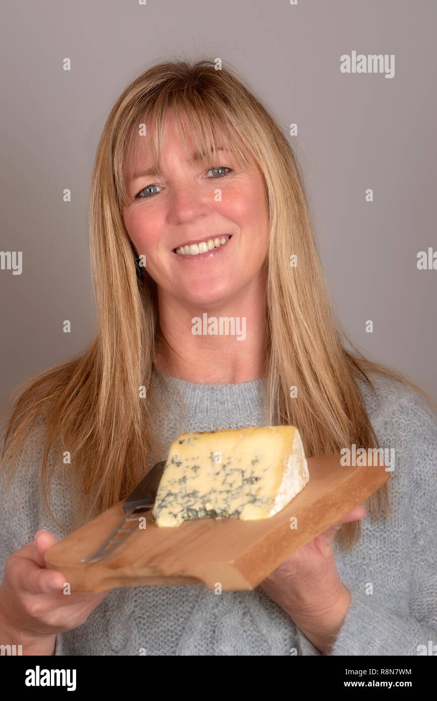 Woman holding a cheese board and a slice of blue cheese Stock Photo Alamy