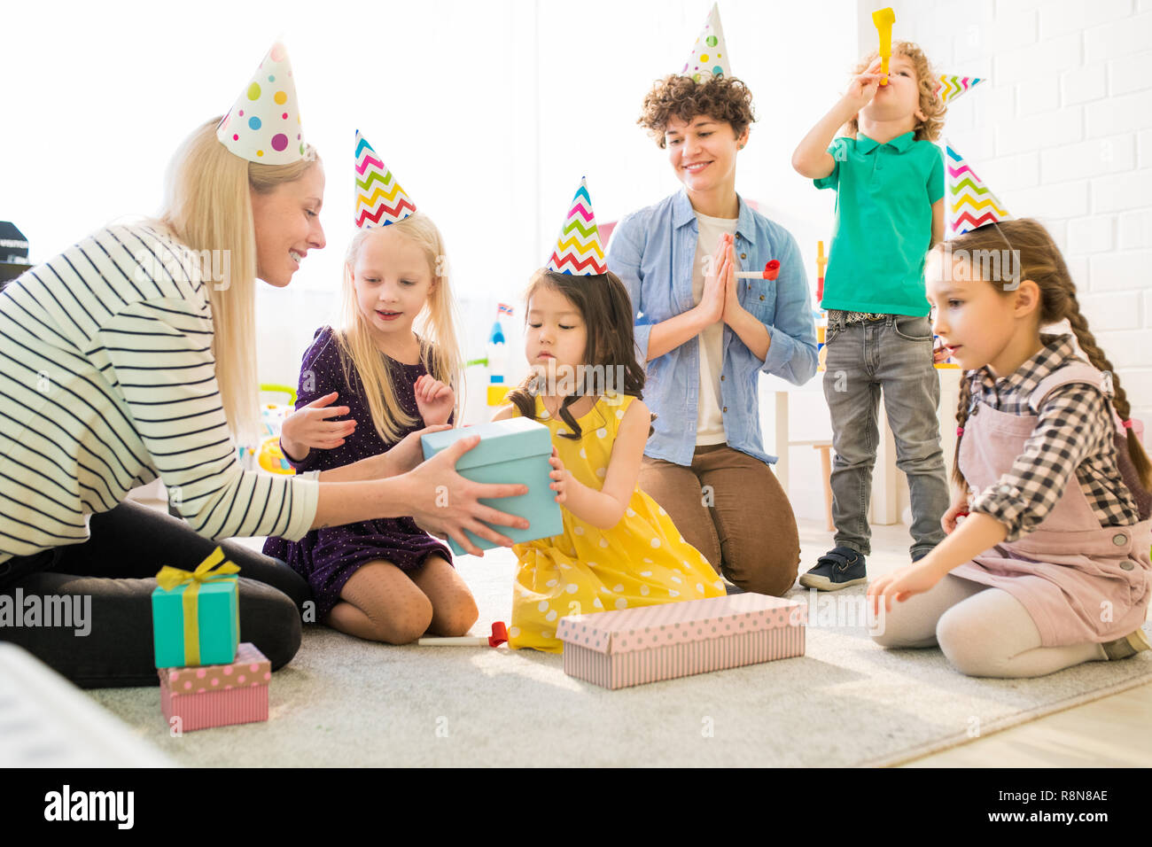 Cheerful kids opening gift box at birthday party Stock Photo