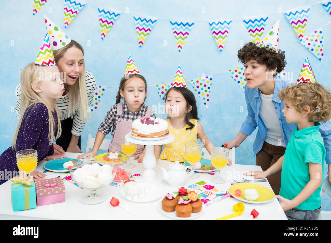 Kids blowing out candles at birthday party Stock Photo Alamy