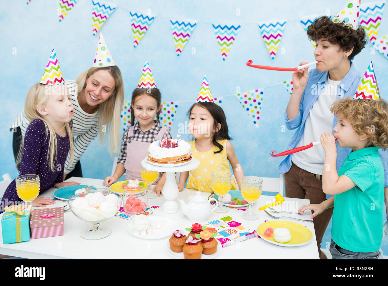 Cute girls blowing out candles on cake Stock Photo Alamy