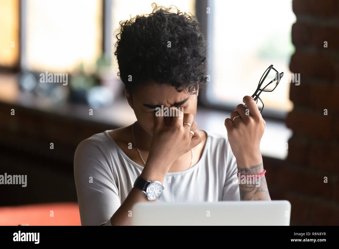 African American woman taking off glasses, feel eye strain Stock Photo