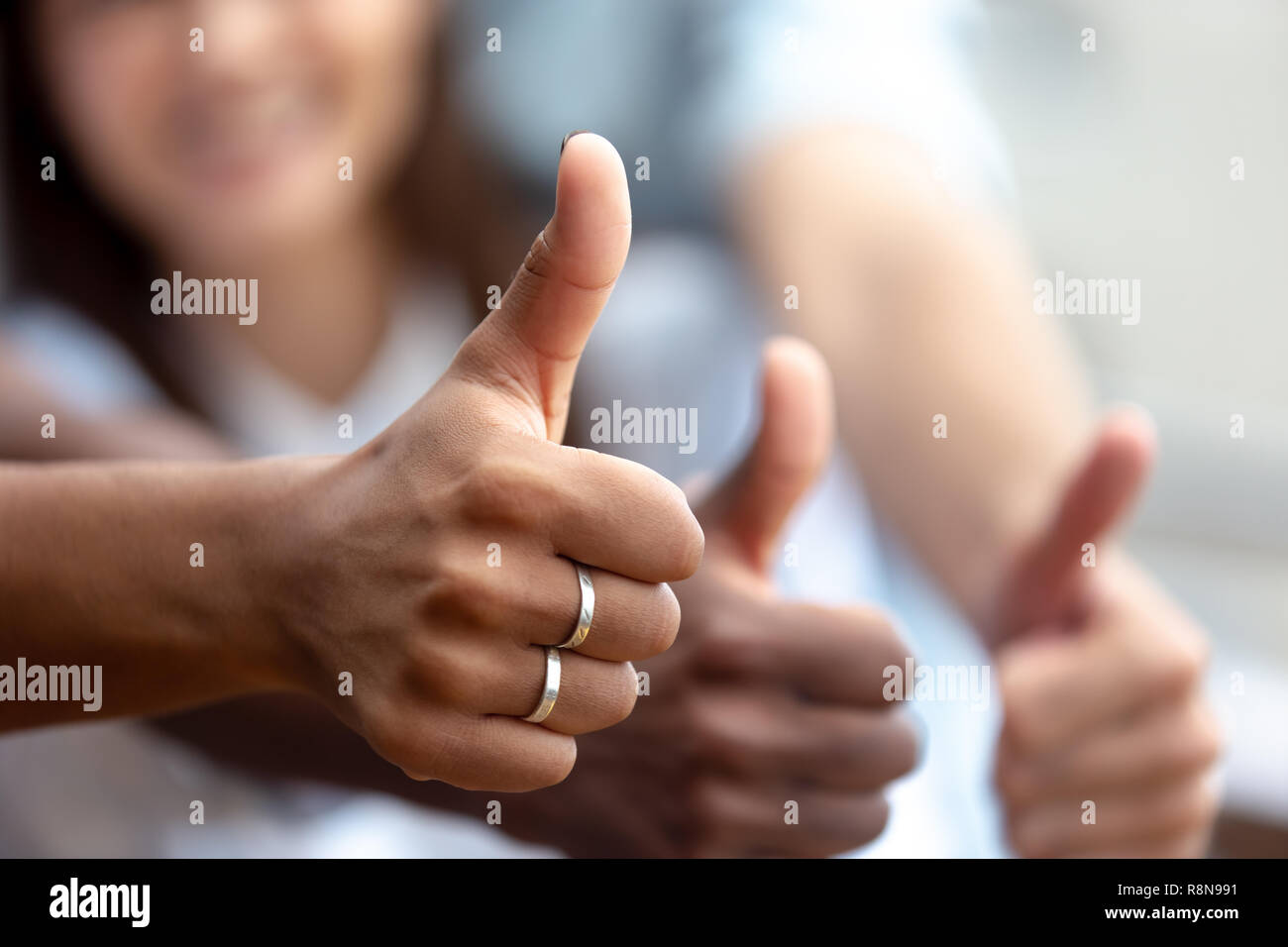 Happy multiethnic friends showing thumbs up close up Stock Photo
