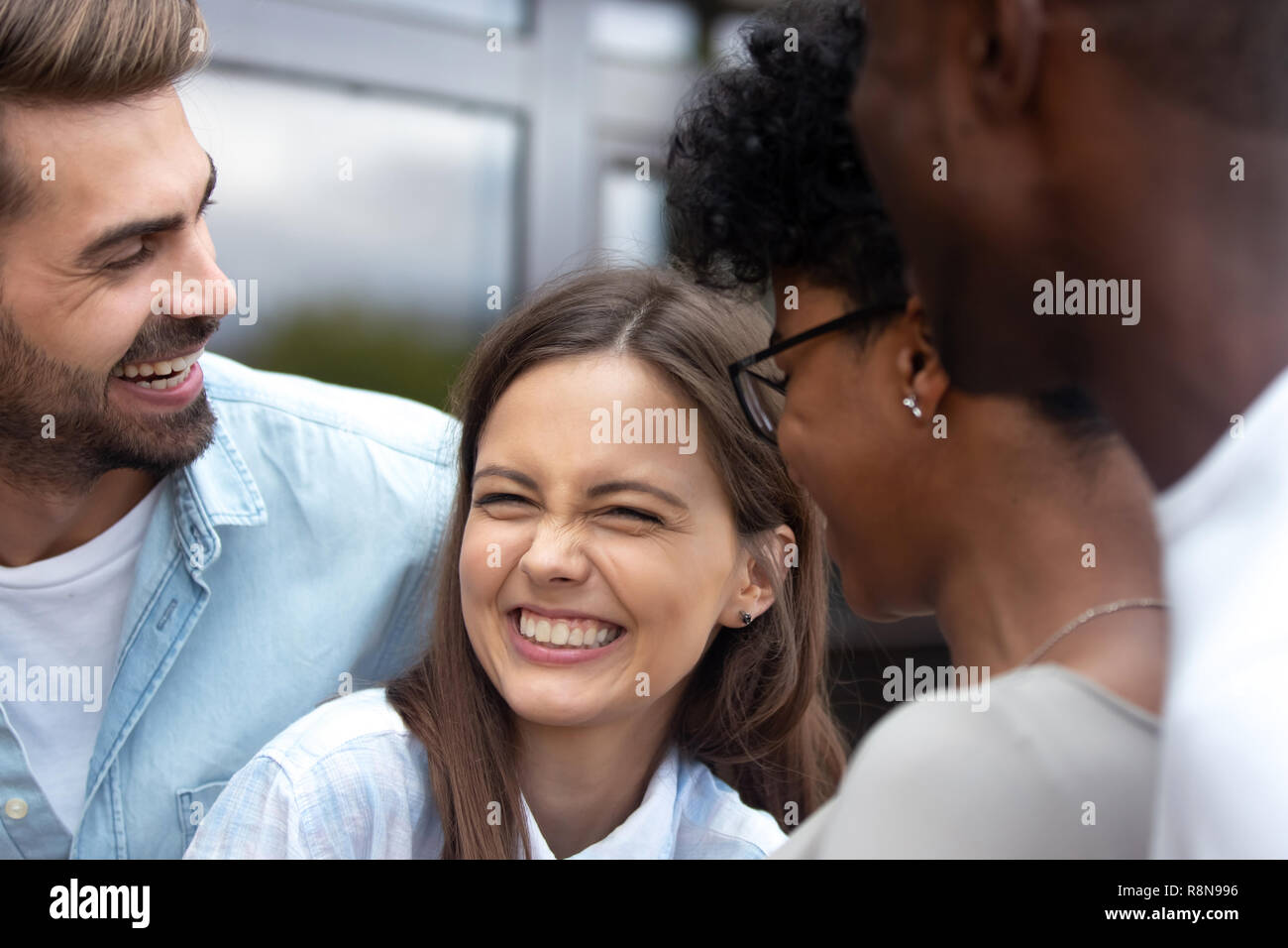 Young happy woman laughing at joke with friends close up Stock Photo