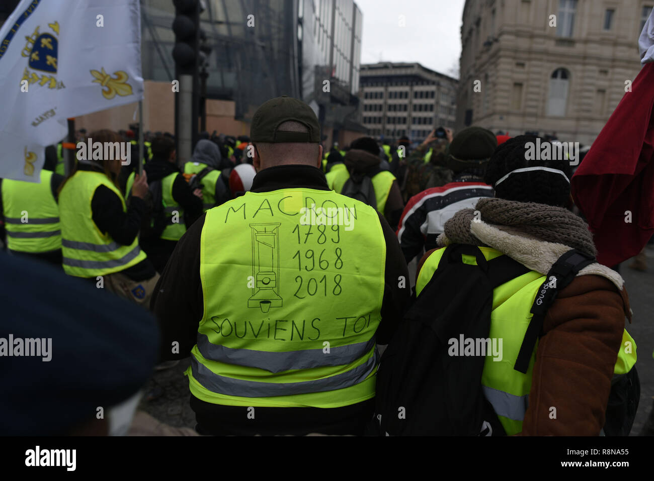 December 08, 2018 - Paris, France: A Yellow Vest protester on the  Champs-Elysees avenue. The message on his vest shows a guillotine and reads  "1789, 1968, 2018 - Macron, remember". Manifestation des