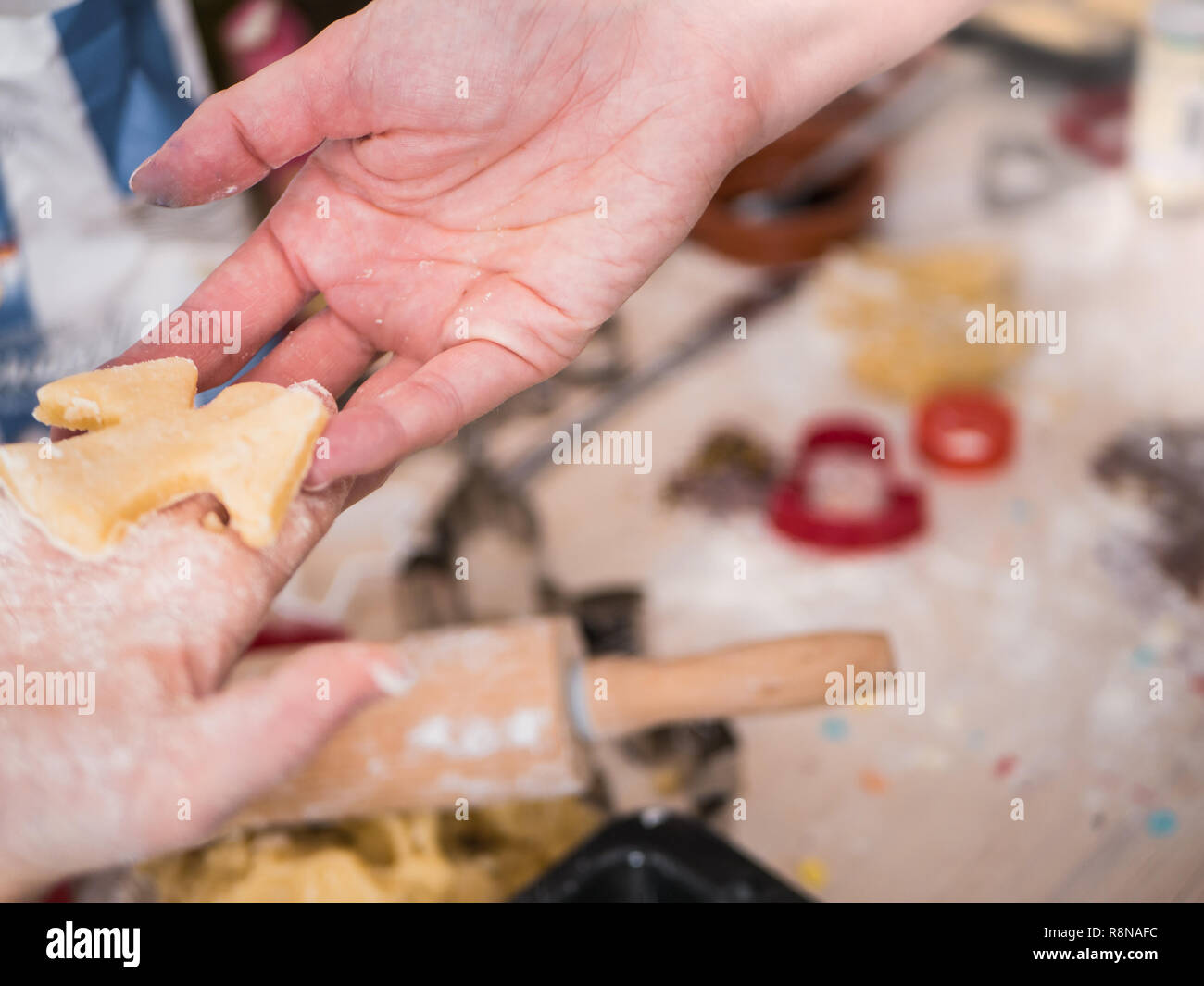 Christmas bakery: Little girl handing over christmas cookies to her mother Stock Photo