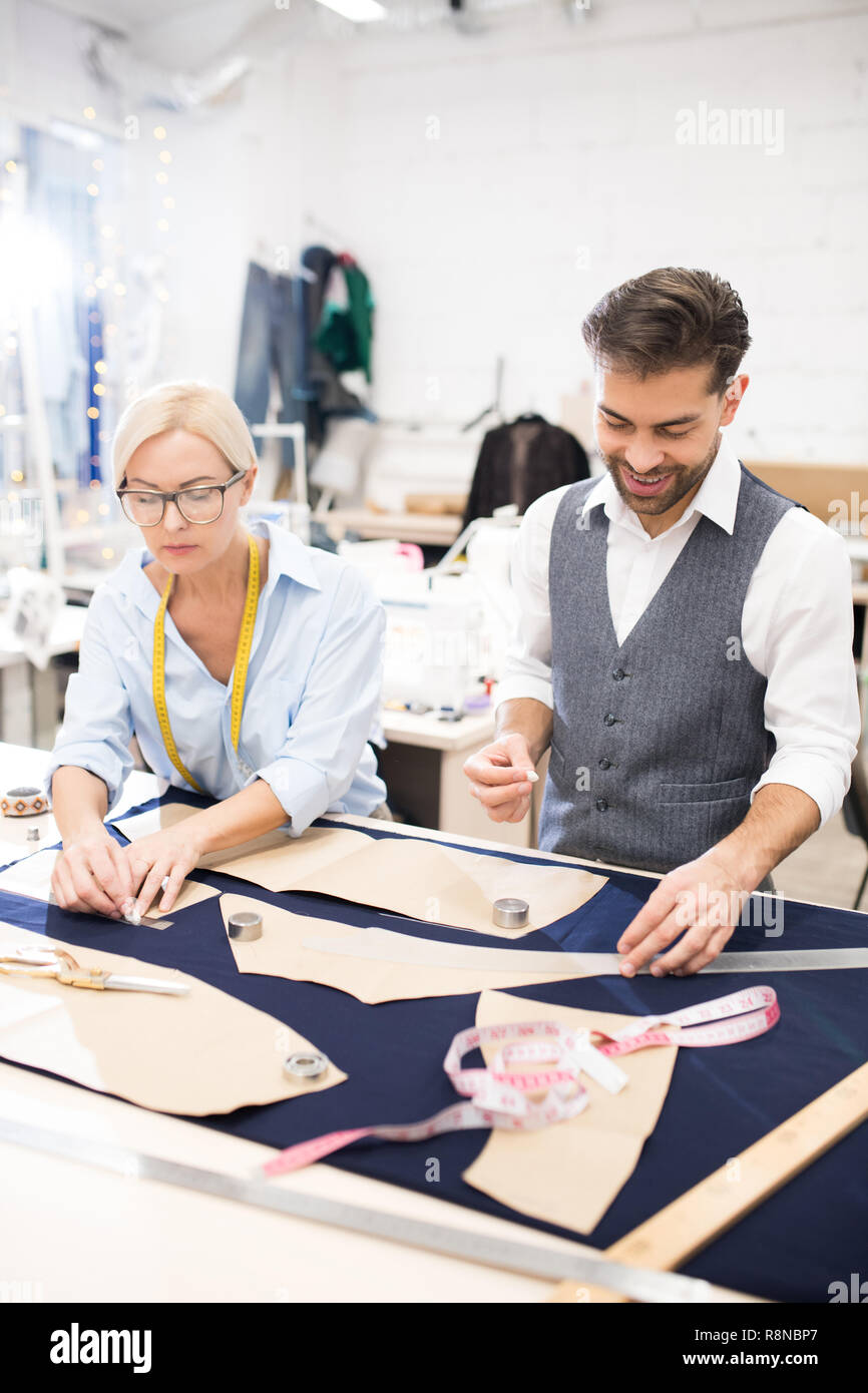 Tailors Working at Table in Atelier Stock Photo - Alamy