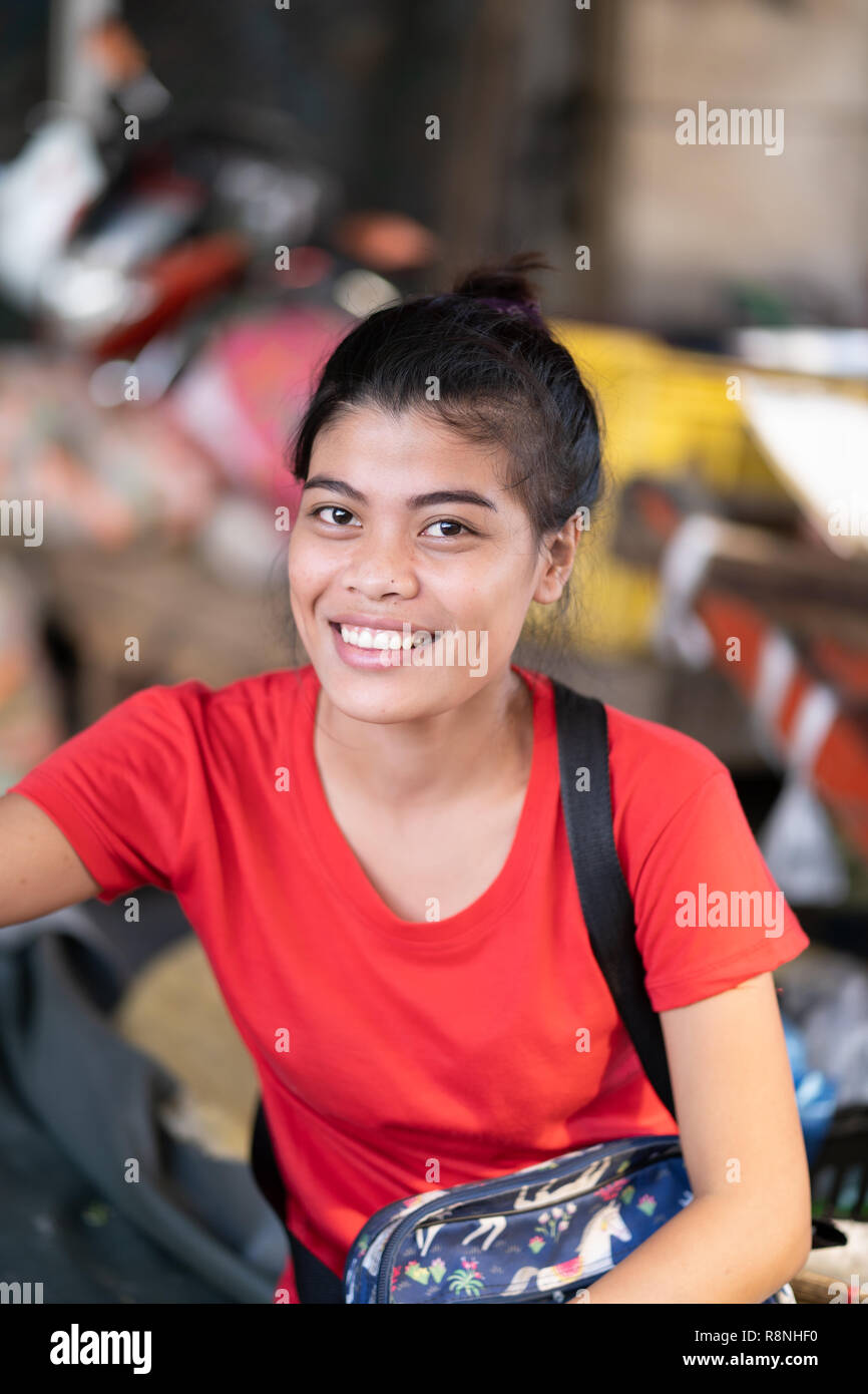 A young Filipina girl working on market stall in Cebu City,smiles for the camera Stock Photo