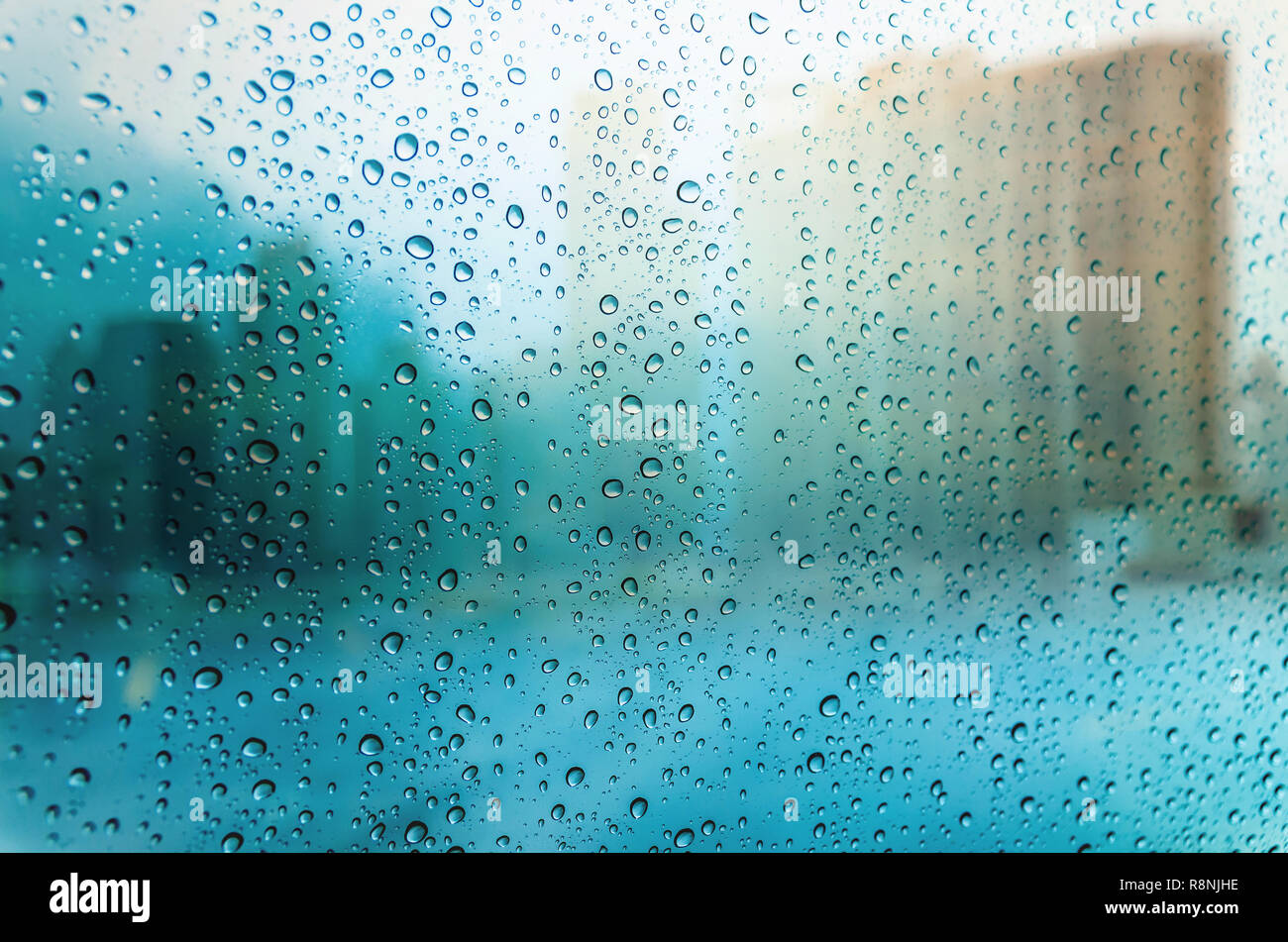 Waterdrops on a glass surface windows with cityscape background Stock Photo