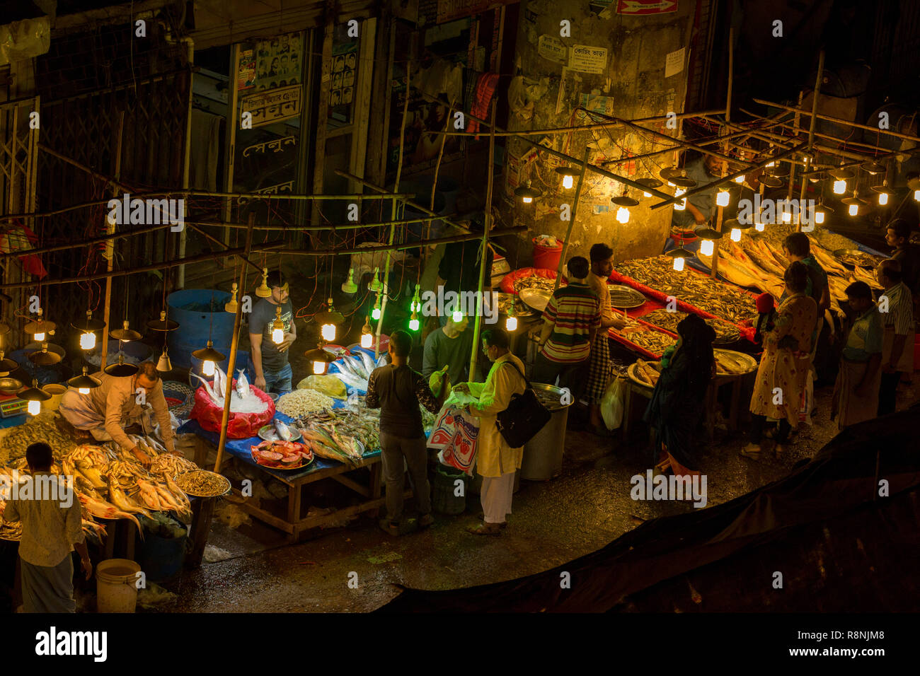 DHAKA, BANGLADESH - DECEMBER 15 : Bangladeshi people browsw fish  in a fish market at night in Dhaka, Bangladesh on December 15, 2018. Stock Photo