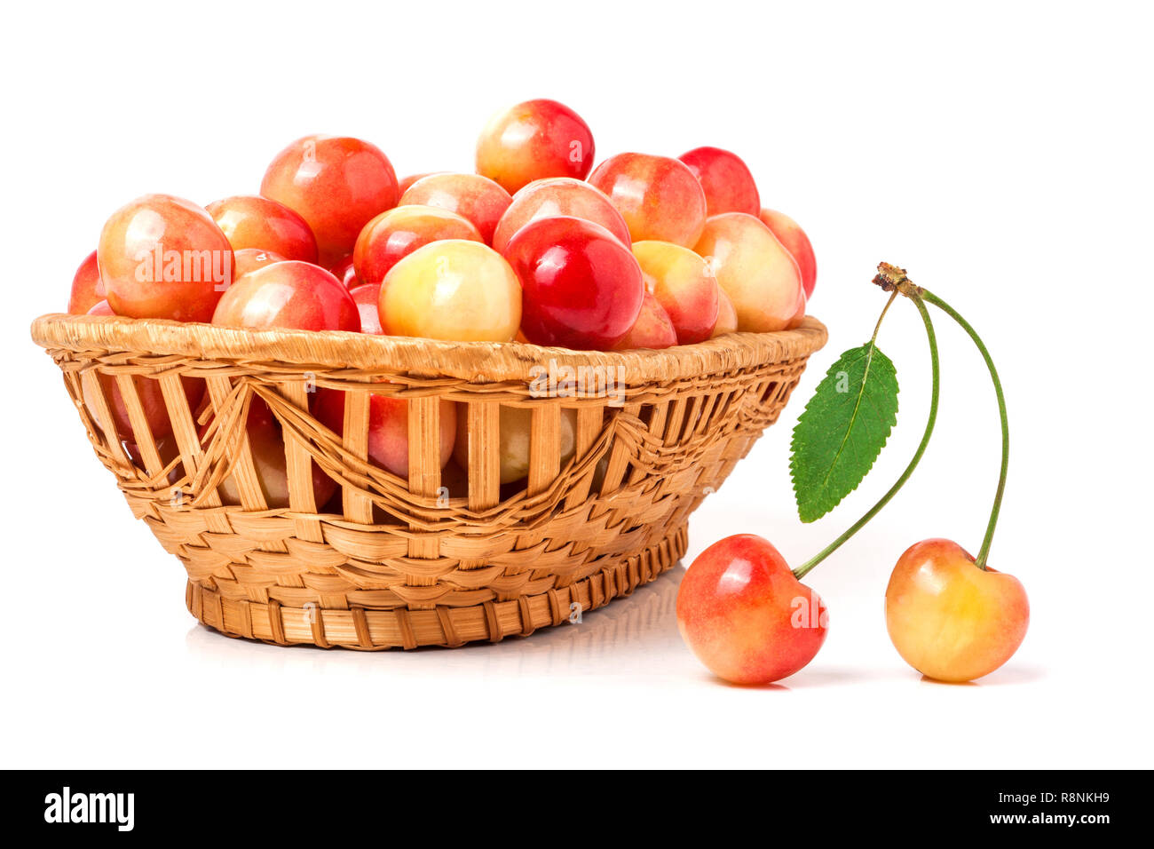 yellow cherries in a wicker basket isolated on white background Stock Photo
