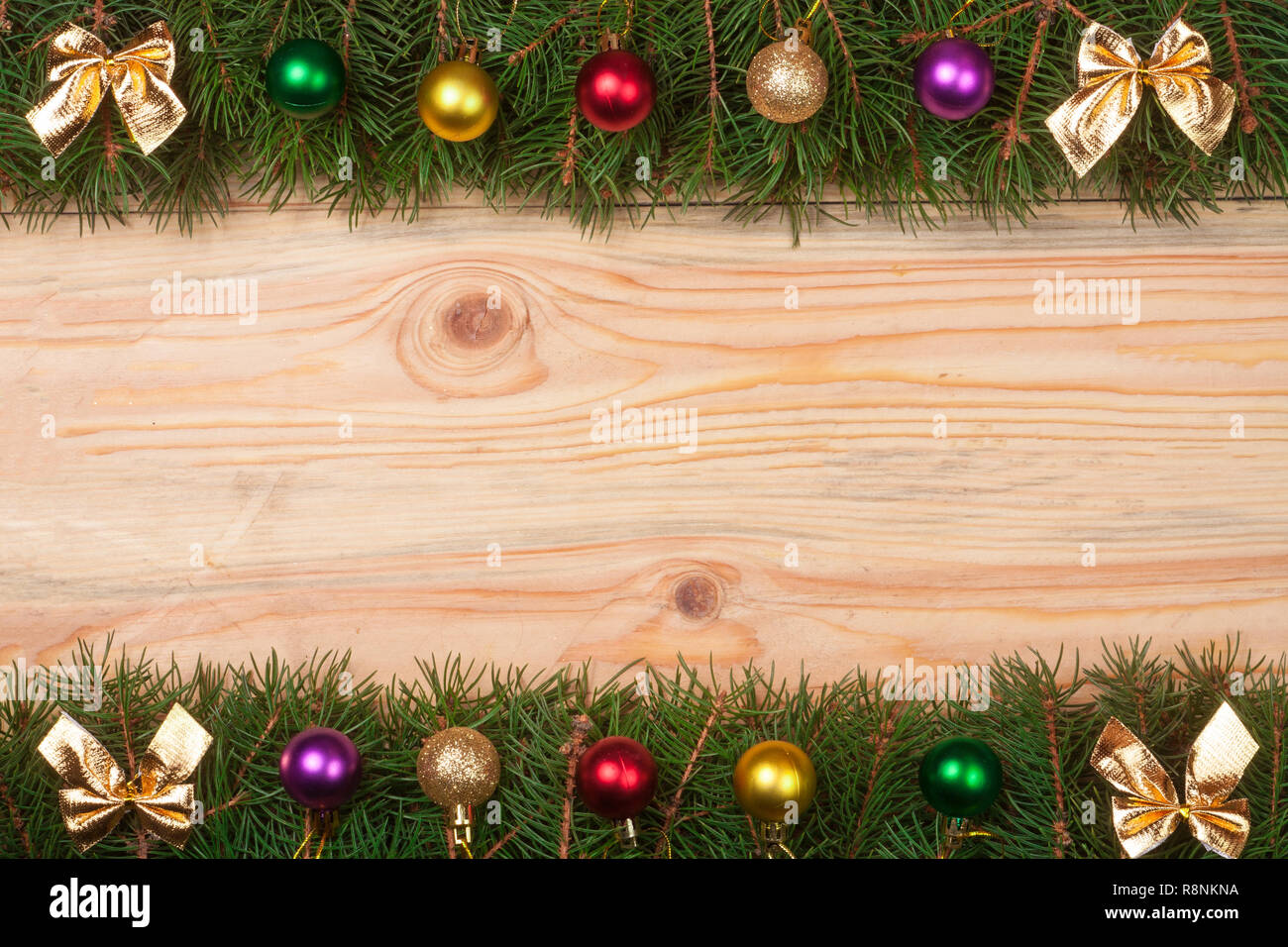 Christmas frame made of fir branches decorated with golden bows and ...