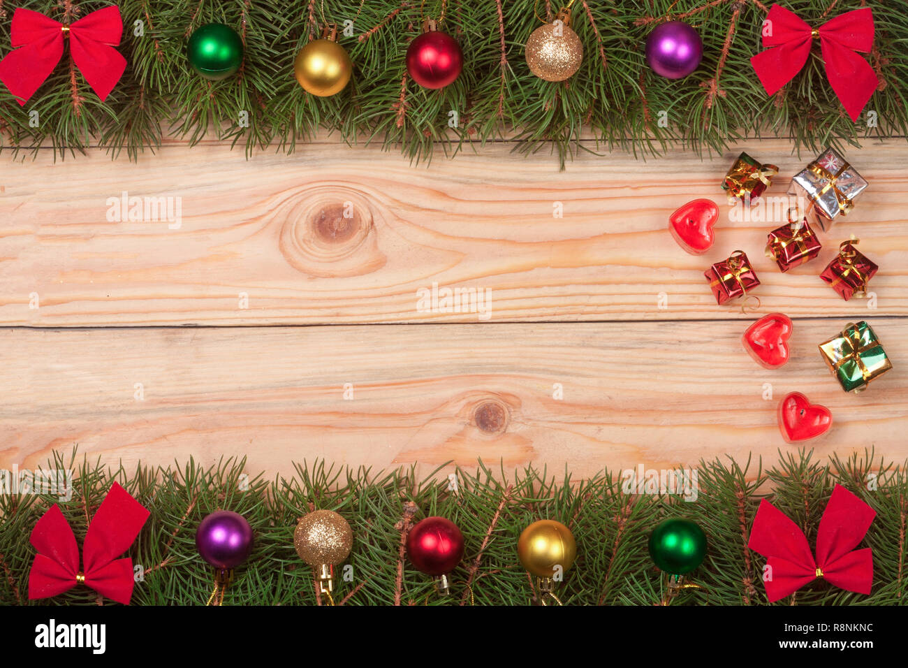 Christmas frame made of fir branches decorated with red bows and balls ...
