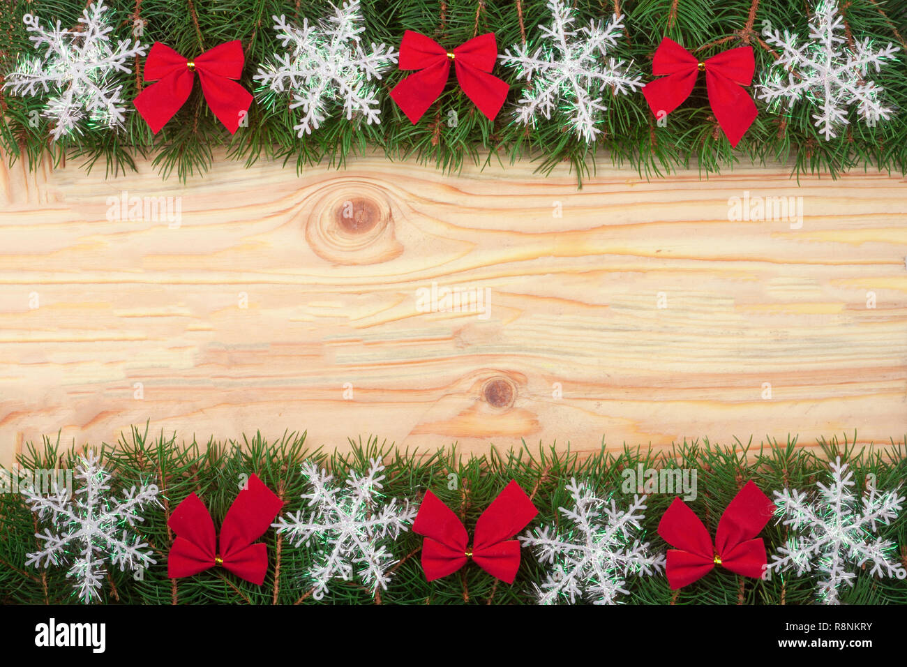 Christmas frame made of fir branches decorated with snowflakes and red ...