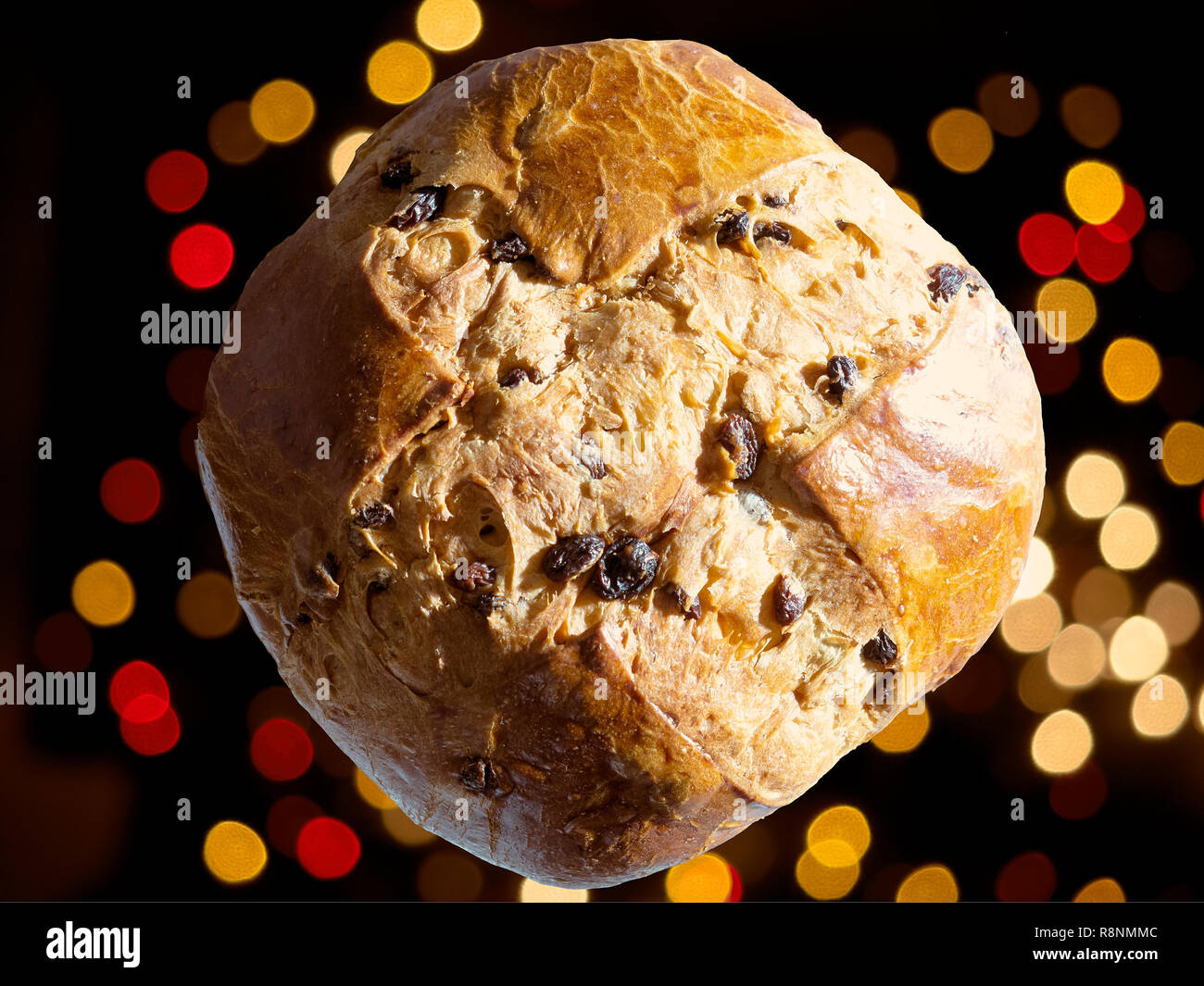 Panettone seen from above, floating on a background lit by Christmas red and yellow lights Stock Photo