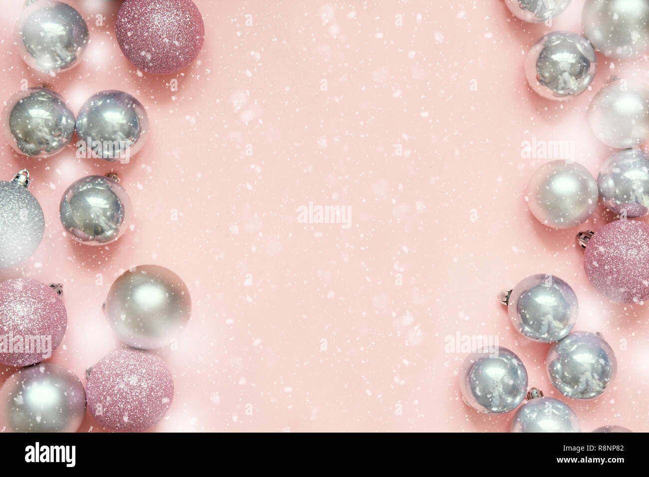 Christmas pink and silver baubles as frame on pastel pink background. Top view with space for text. Flat lay. Stock Photo