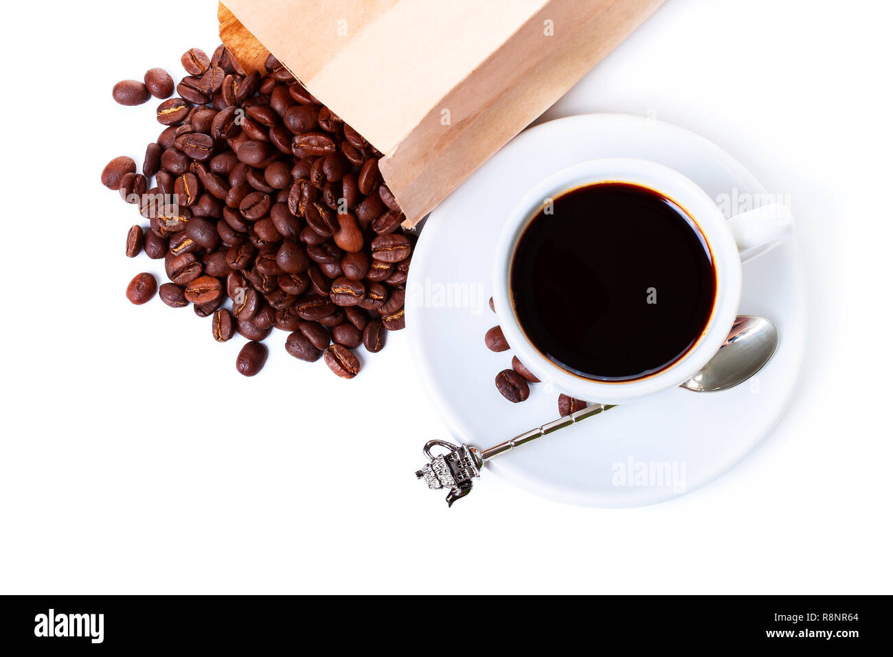 white cup of black coffee near the laying paper bag with coffee beans Stock Photo
