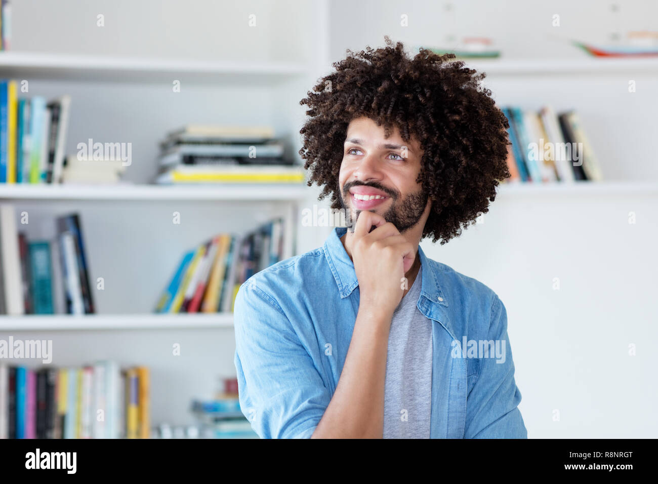 Thinking hipster man with afro hair indoor at home Stock Photo