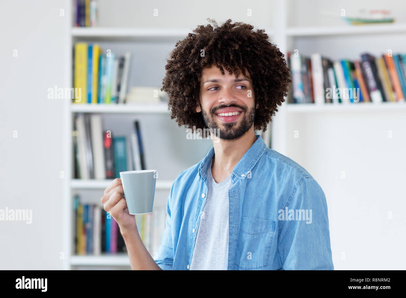 Hipster Man With Afro Hair Relaxing And Drinking Coffee Indoor At