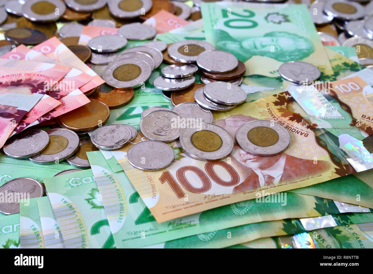 Many canadian dollar bills and spare change spread and filling the frame. Stock Photo