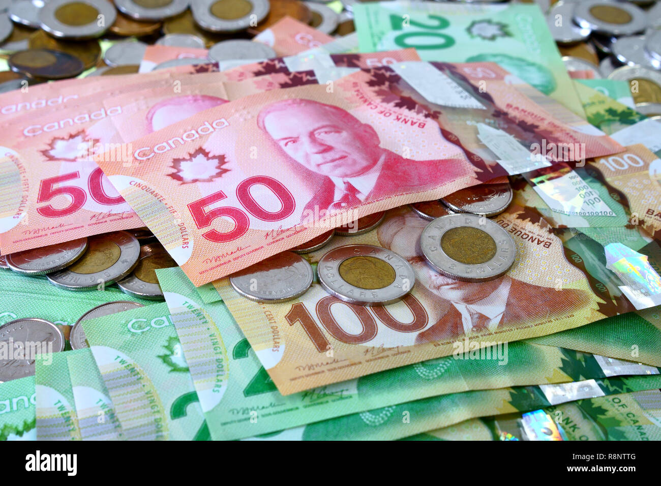 Many canadian dollar bills and spare change spread and filling the frame. Stock Photo