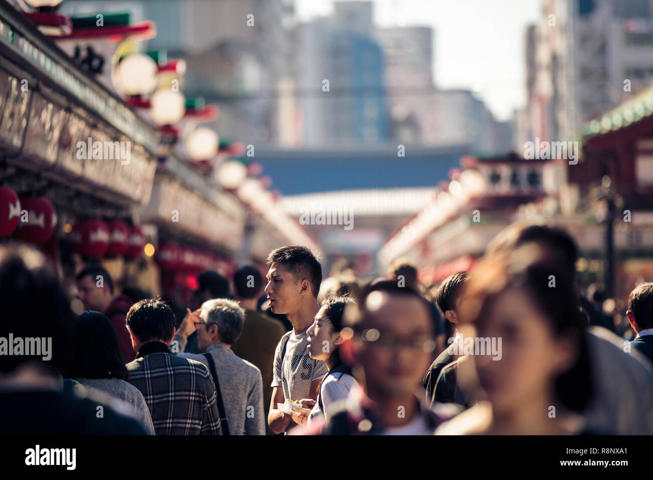 Locals and tourists throng the famous shopping street of Nakamise-dōri next to the Sensō-ji temple in Tokyo. Stock Photo