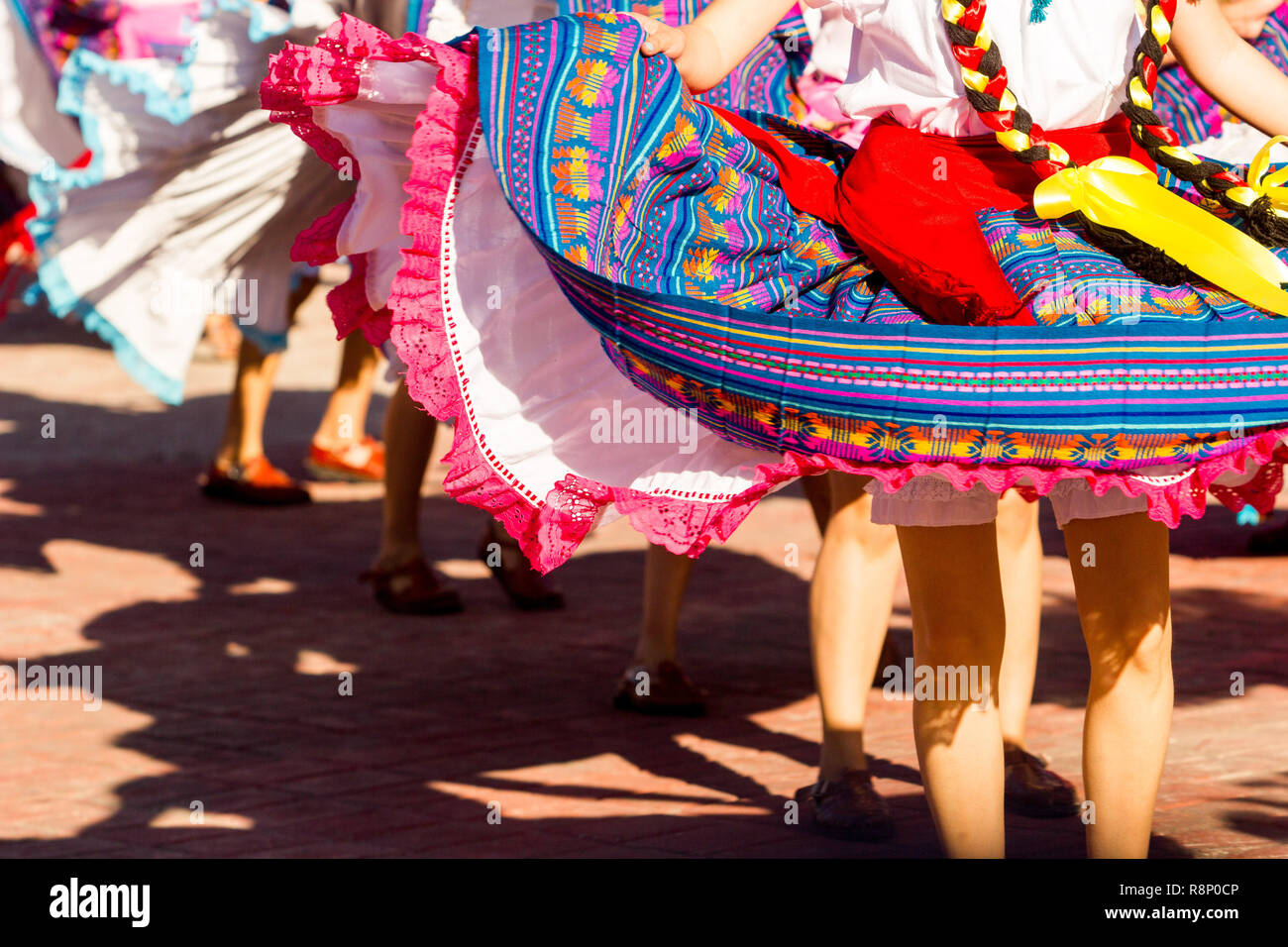 dance crew of female dancers wearing colorful traditional dresses dance
