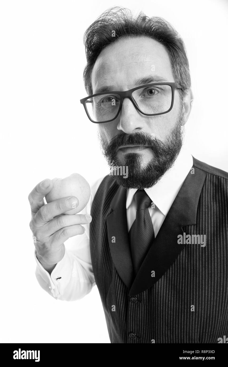 Guide to prescription eyeglass lenses and frames. Businessman classic formal clothing and proper eyewear holds eat apple. Businessman formal eyewear choice. Healthy vision sight nutrition tips. Stock Photo