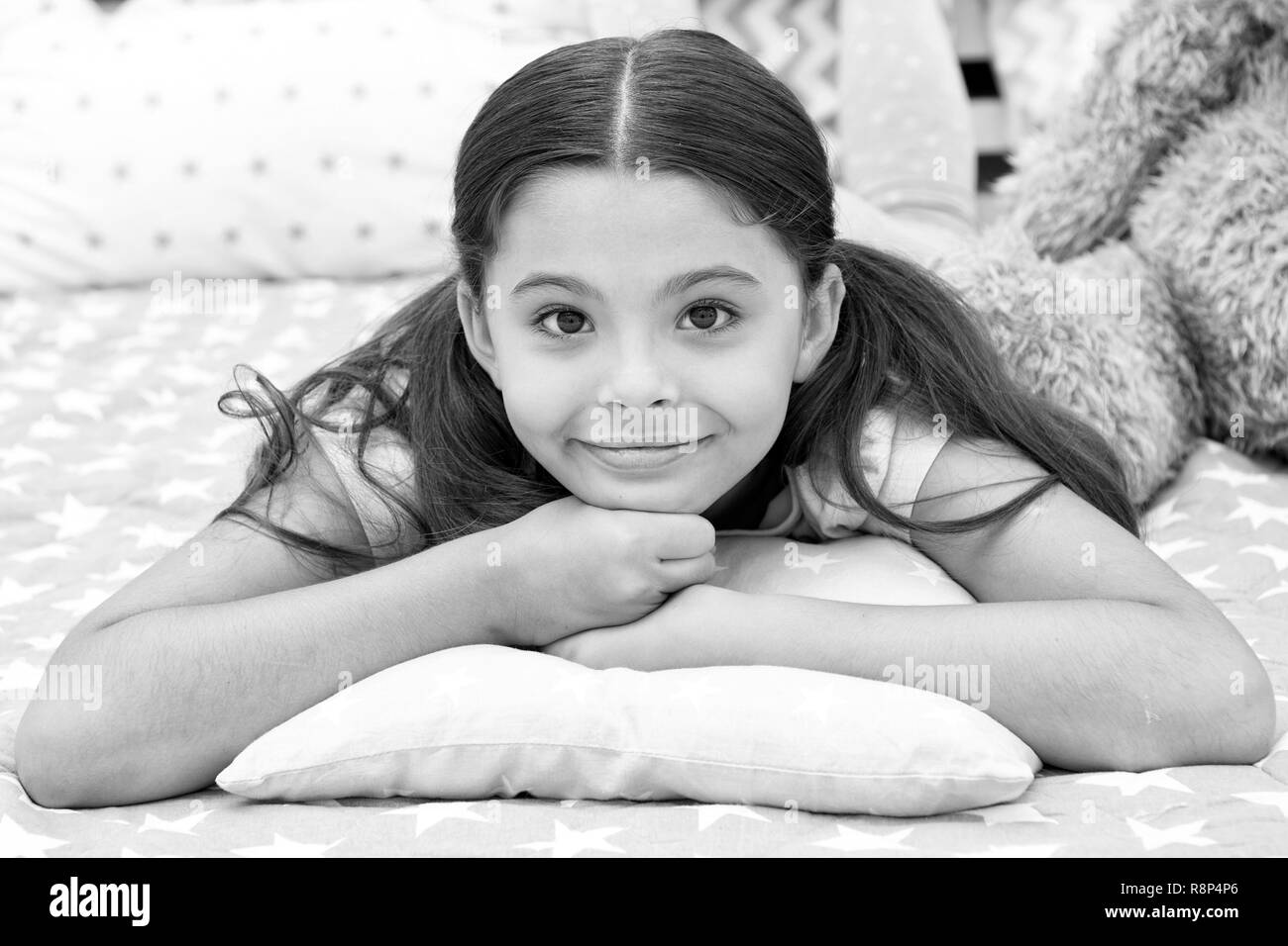 Just relaxing. Girl child lay on pillow in her bedroom. Kid prepare to