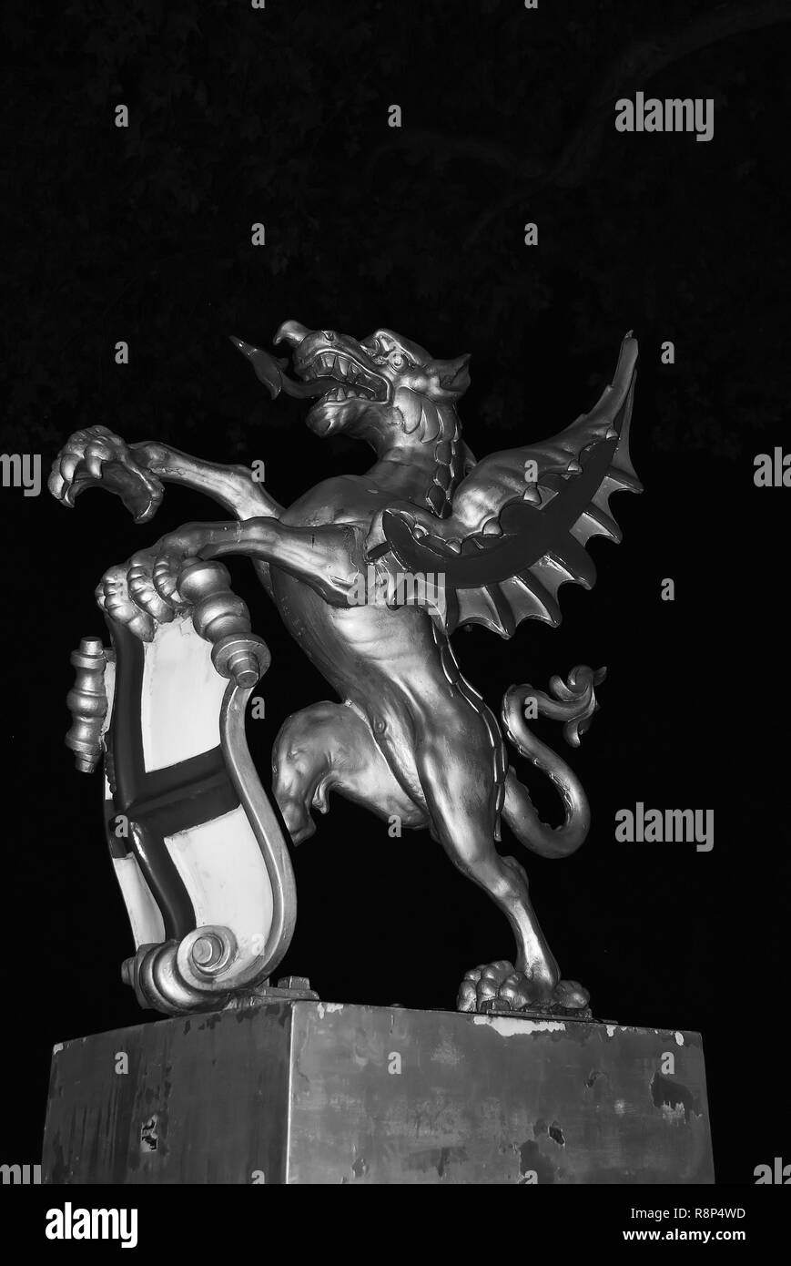 Dragon statue in London, United Kingdom. Dragon with shield on dark sky