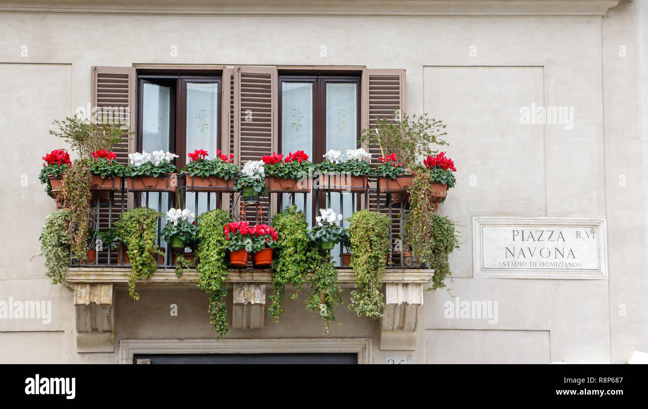 Balcony with flowers on an old yellow apartment building in Rome Italy
