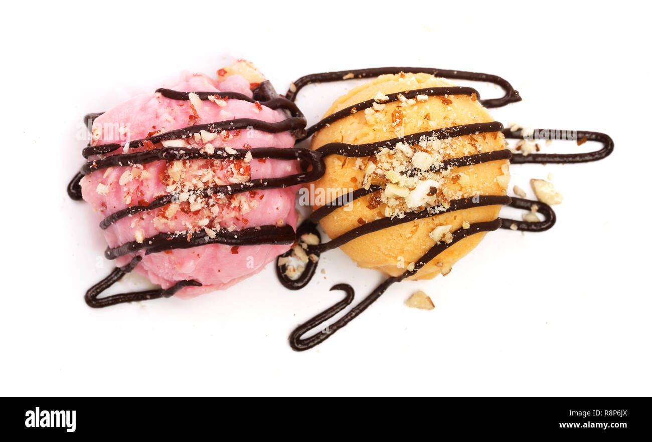 Yellow and pink ice cream with melted chocolate top view isolated on white background Stock Photo