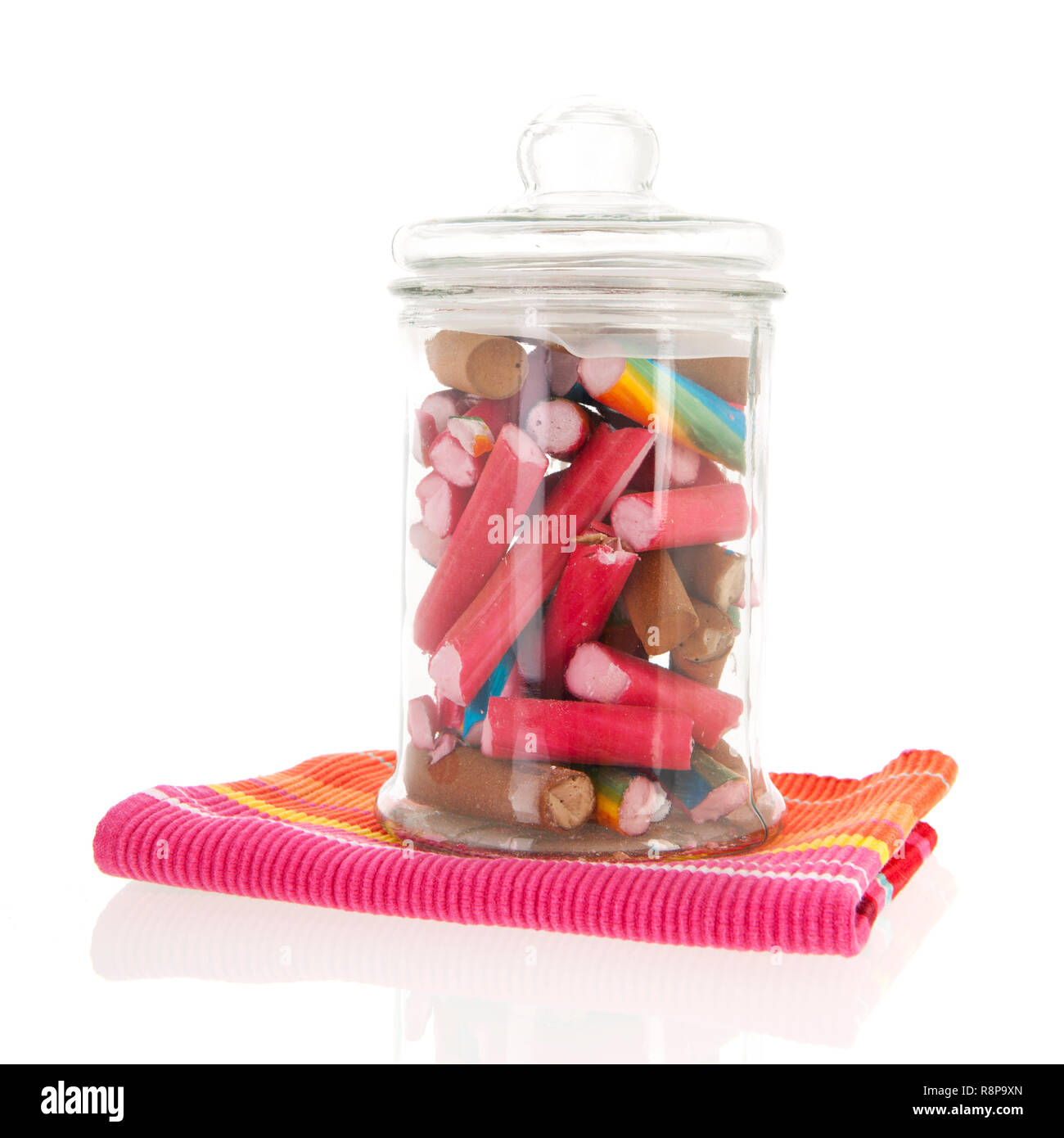Glass pot of colorful candy canes isolated over white background Stock Photo