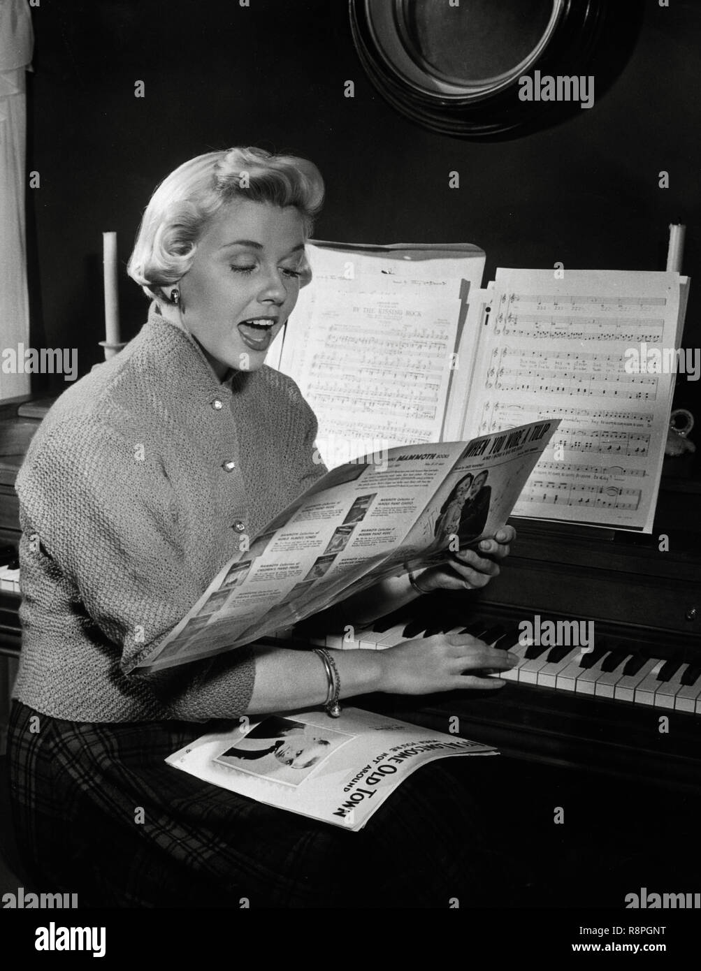 Doris Day, sits at a piano and reads music while singing,  circa 1952  File Reference # 33635 643THA Stock Photo