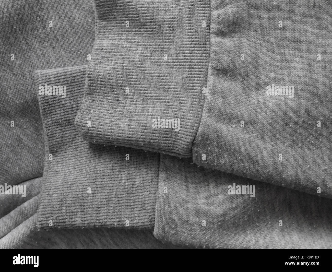Pills on the heather gray sweatshirt cotton knit fabric. Bobbles on the knitwear. Stock Photo