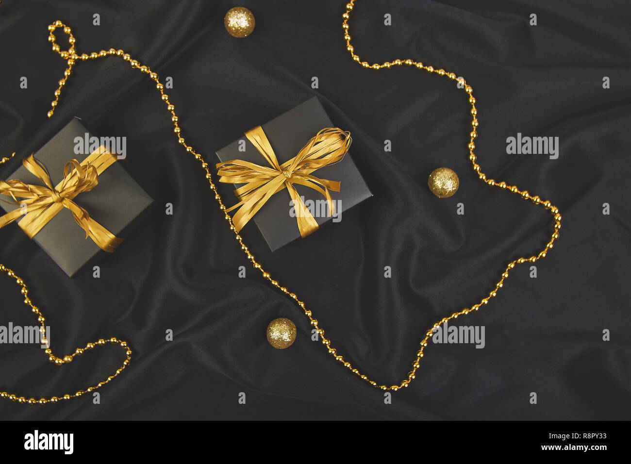 View of Luxury black gift boxes with gold ribbon on shine background. Christmas ...