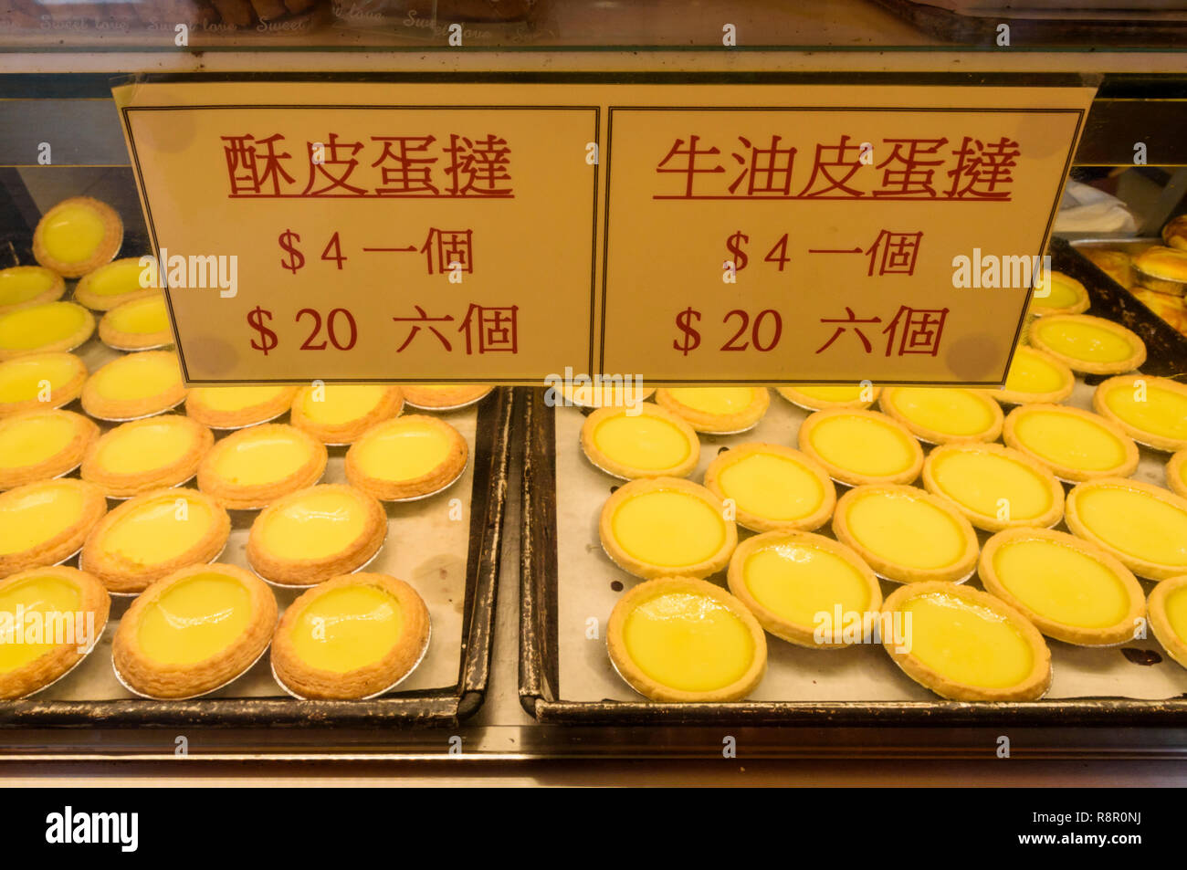 Different types of egg tarts for sale at the Red Cherry Bakery in Sham Shui Po, Hong Kong Stock Photo