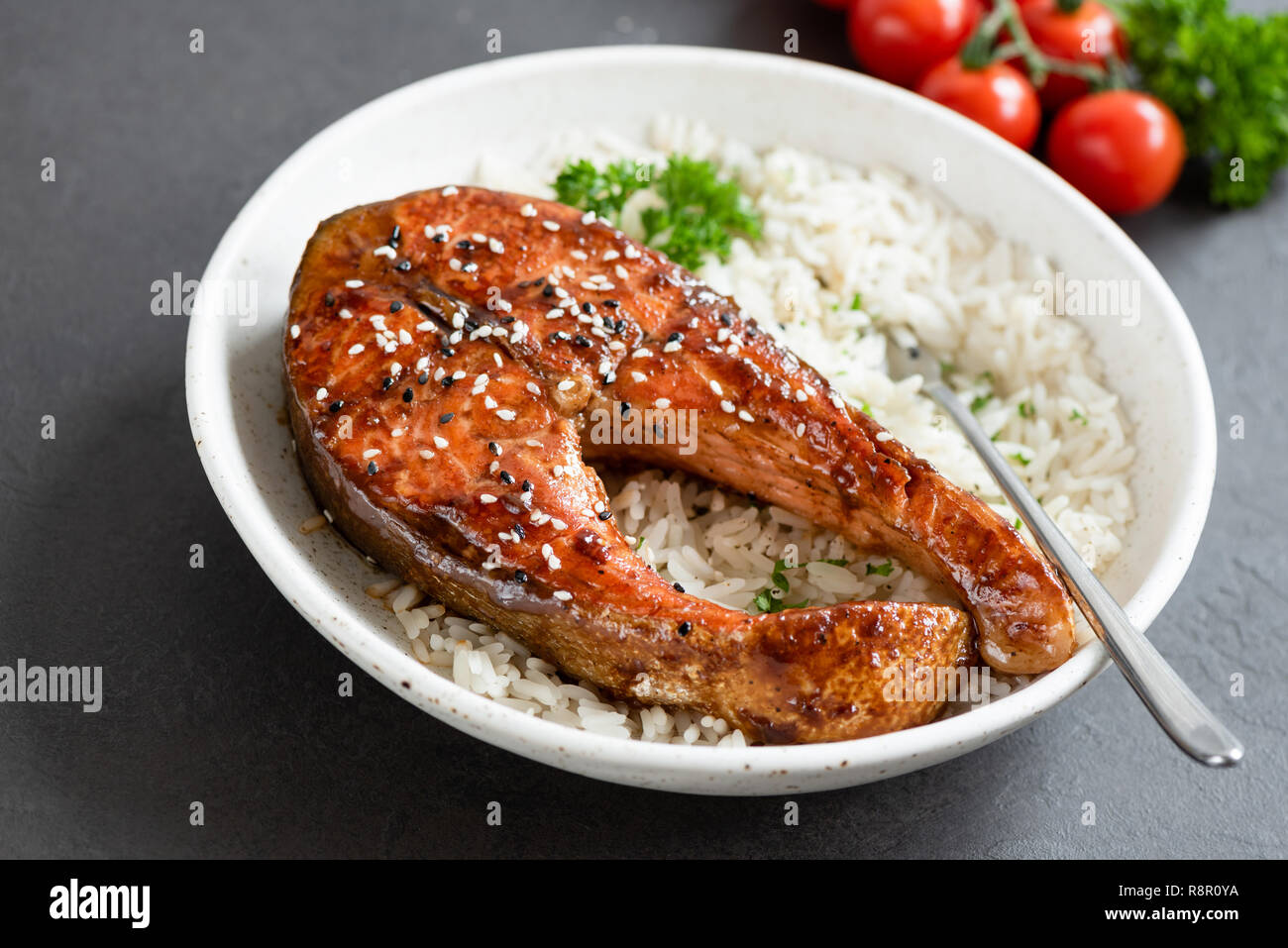 Grilled salmon steak with teriyaki sauce and white rice on a plate. Tasty dinner Stock Photo