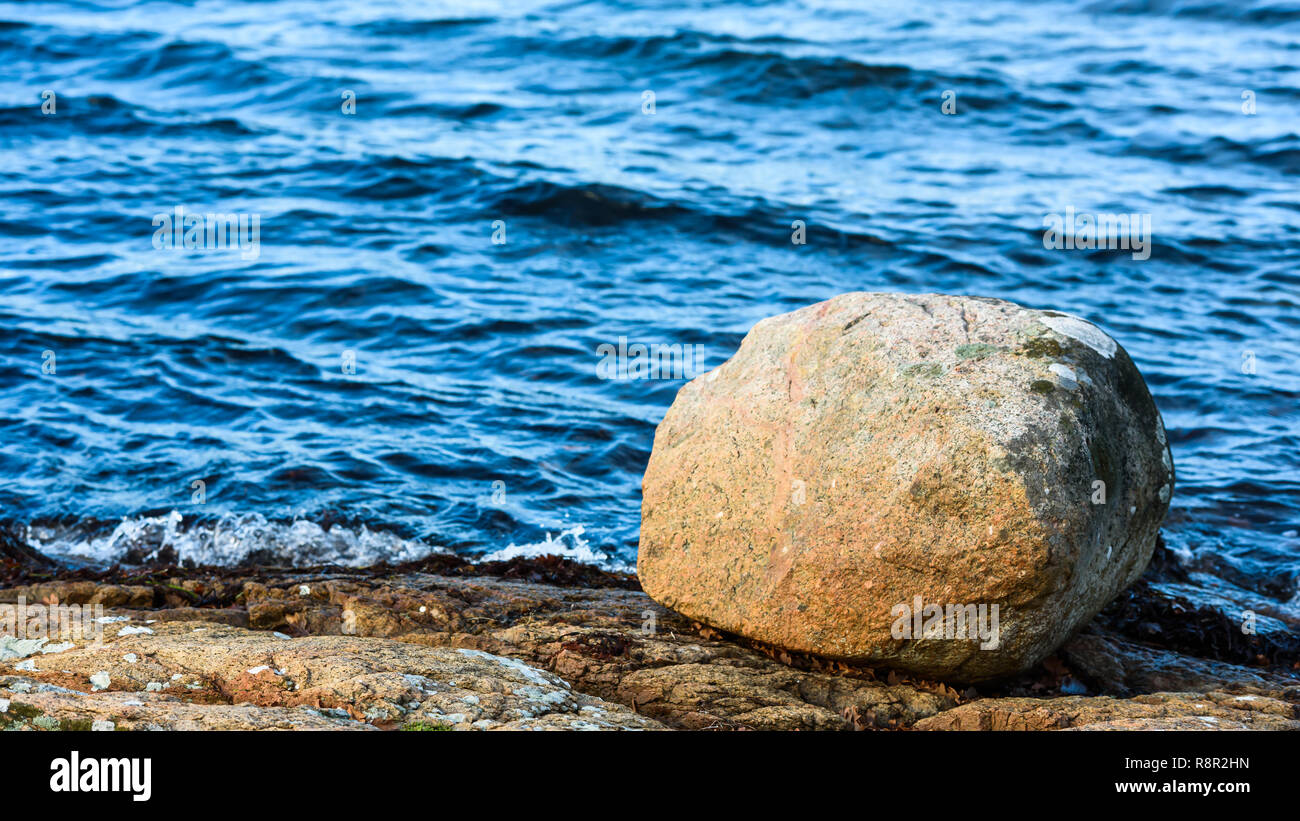 Granite boulder on rocky shore. Stock Photo